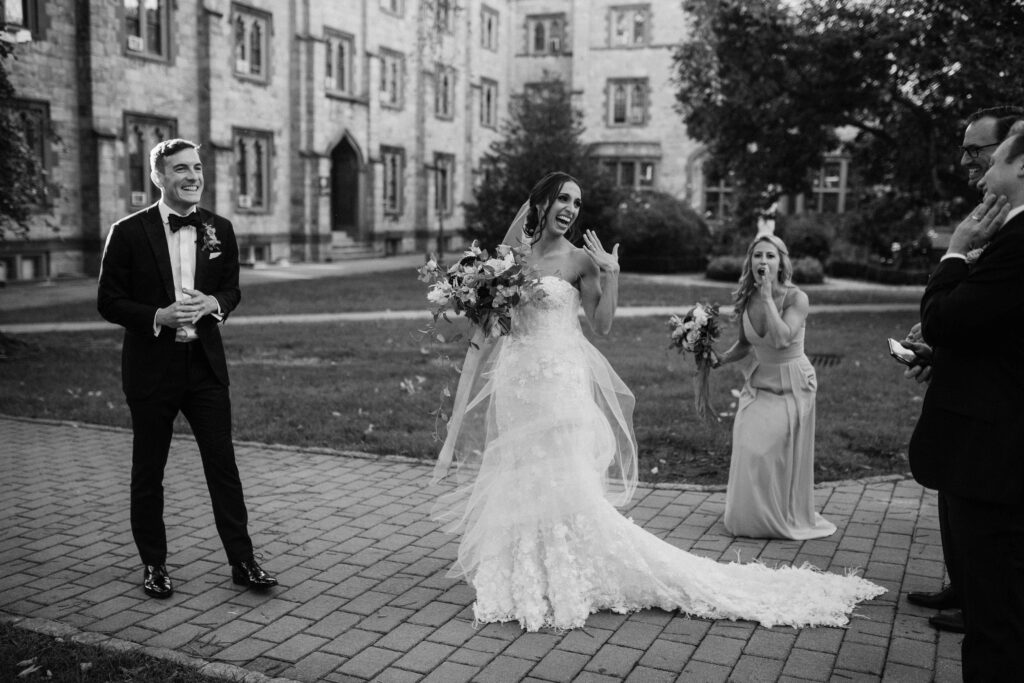 a wedding photographer captures newlyweds with some of their guests outdoors