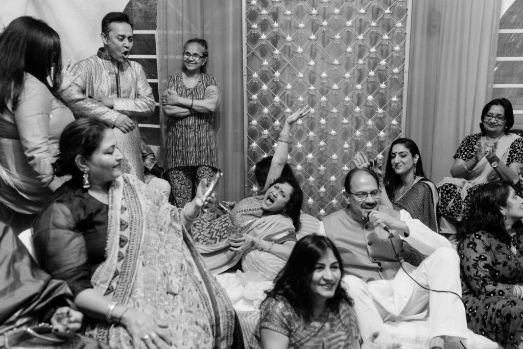 wedding guests smile and laugh during a south asian celebration